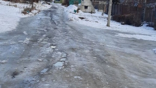 В Заводском районе по улице льется вода и заковывает дома в лед